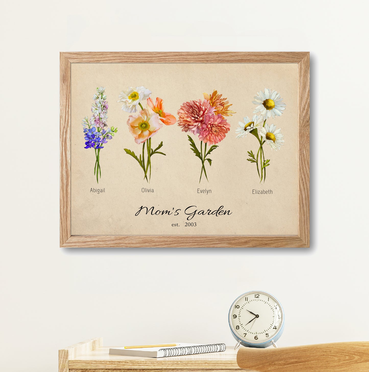 A framed "Grandma’s Garden" birth month flower print hanging on a white living room wall above a wooden console table